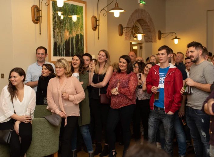 Spectators watching something out of frame, smiling and laughing